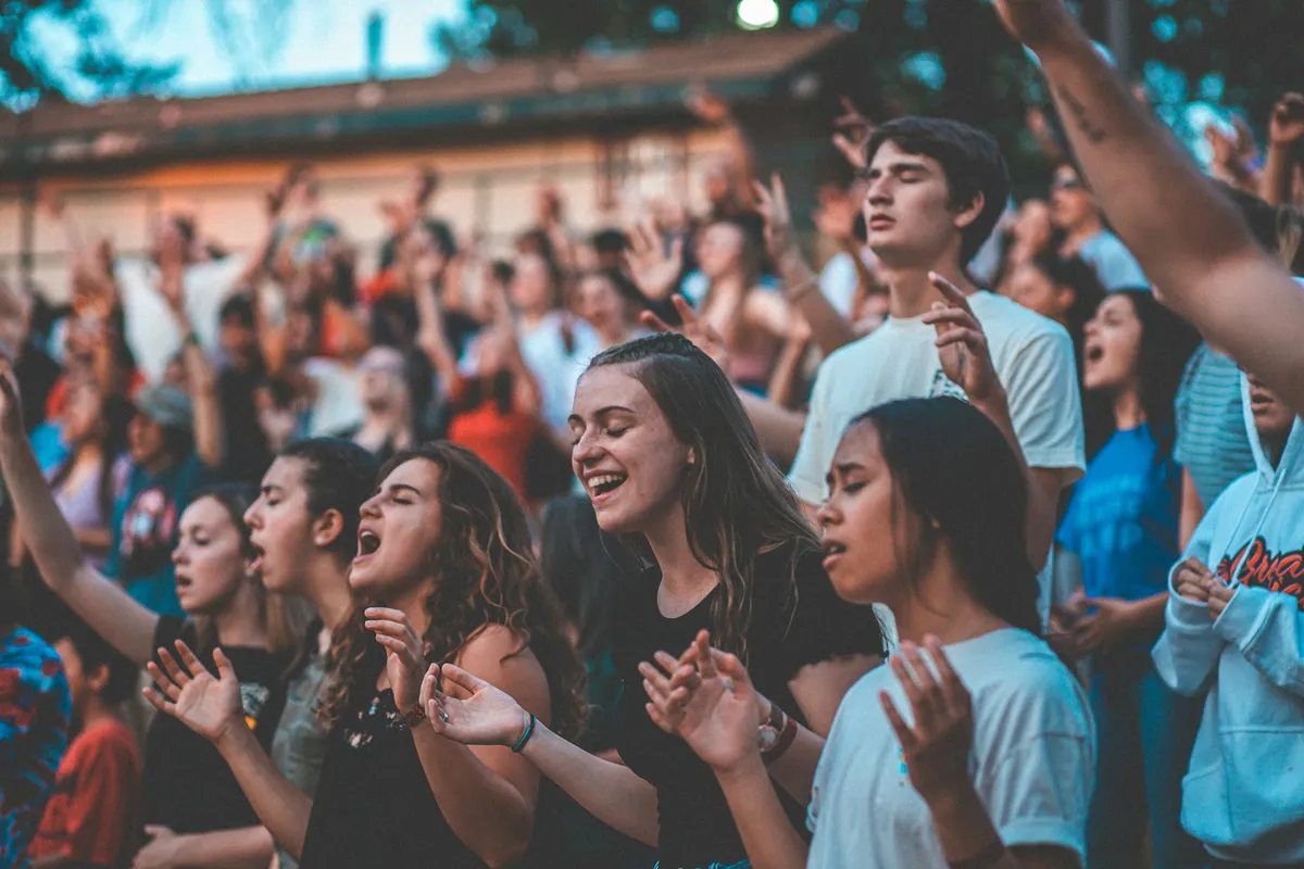 Young people singing together at an outdoor youth gathering